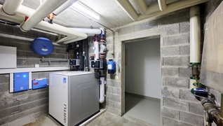 La chaufferie avec la nouvelle installation de pompe à chaleur et les deux chauffe-eaux.