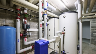 La chaufferie avec la nouvelle installation de pompe à chaleur et les deux chauffe-eaux.